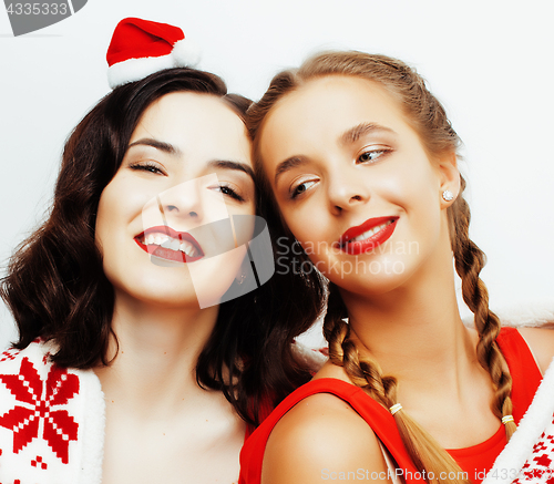Image of young pretty happy smiling blond and brunette woman girlfriends on christmas in santas red hat and holiday decorated plaid, lifestyle people concept 
