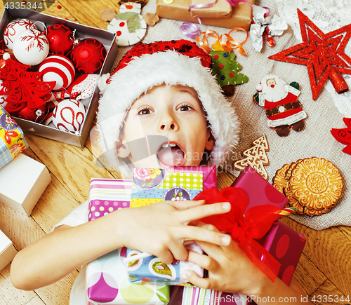 Image of little cute kid in santas red hat with handmade gifts, toys vint