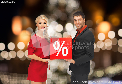 Image of couple with discount sign over christmas lights