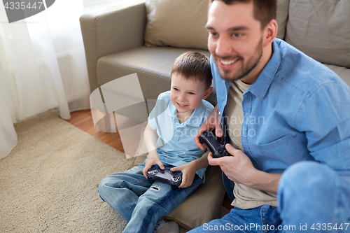 Image of father and son playing video game at home