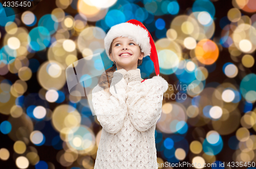 Image of dreaming girl in santa helper hat over lights