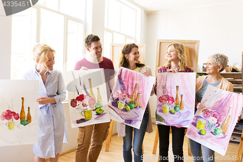 Image of group of artists with pictures at art school