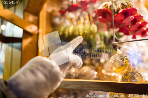 Image of hand pointing at christmas toys behind shop window