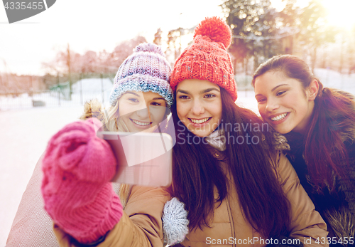 Image of happy teenage girls taking selfie with smartphone