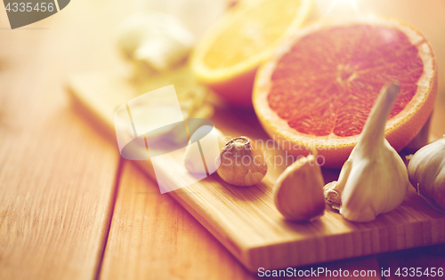 Image of garlic, grapefruit, ginger, and orange on board