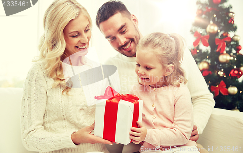 Image of happy family at home with christmas gift box