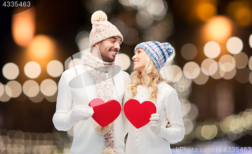 Image of couple with red hearts over christmas lights