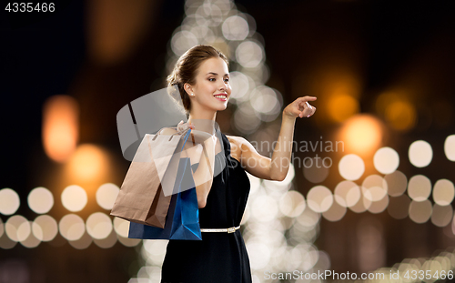 Image of woman in black with shopping bags at christmas