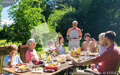 Image of happy family having dinner or summer garden party