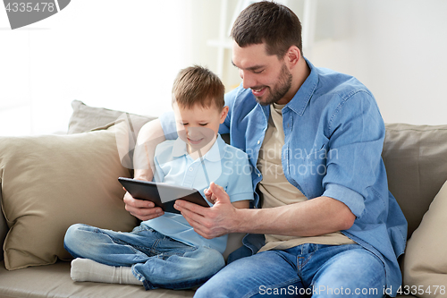 Image of father and son with tablet pc playing at home
