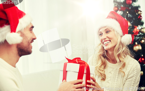 Image of happy couple at home with christmas gift box