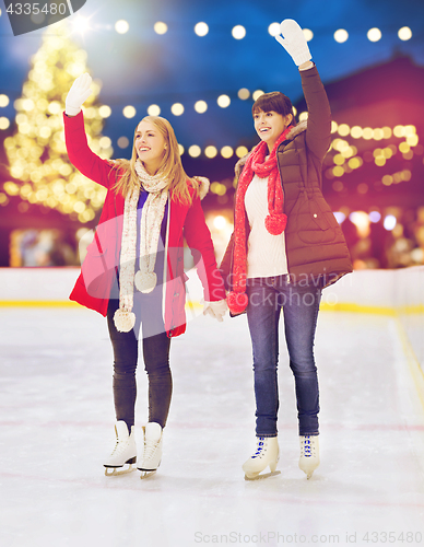 Image of women waving hands at christmas skating rink