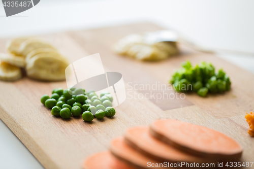 Image of peas and other vegetables on wooden board