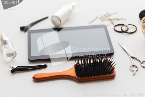 Image of tablet pc, scissors, brushes and other hair tools