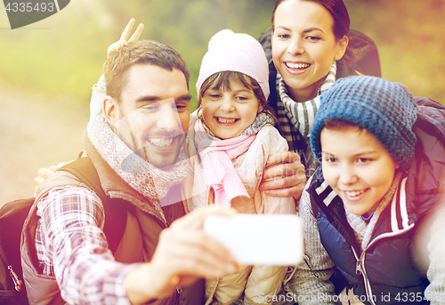 Image of family taking selfie with smartphone in woods