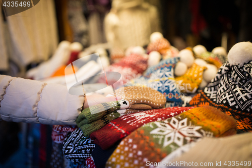 Image of woman buying woolen mittens at christmas market