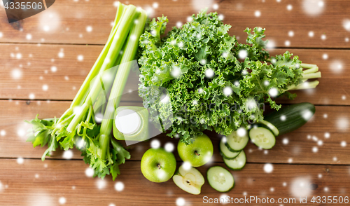 Image of close up of bottle with green juice and vegetables