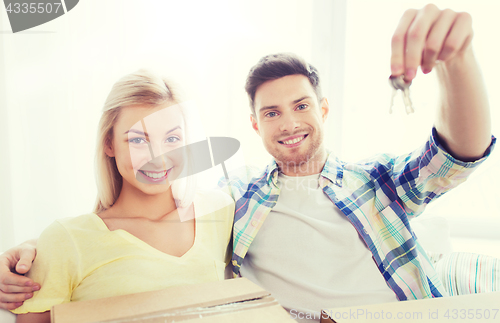 Image of happy couple with key and boxes moving to new home