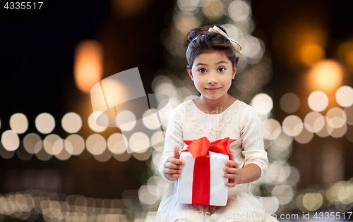 Image of happy girl with gift box over christmas lights