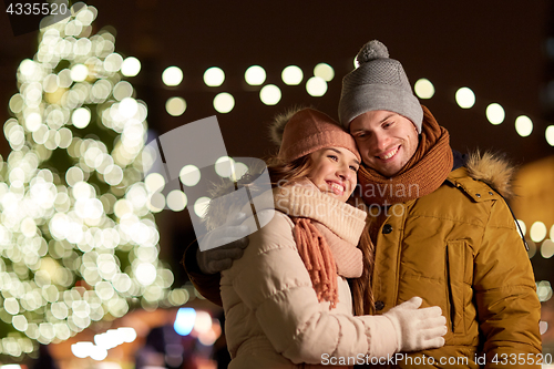 Image of happy couple hugging at christmas tree