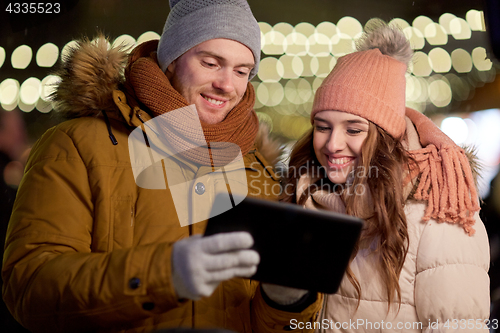 Image of happy couple with tablet pc at christmas market