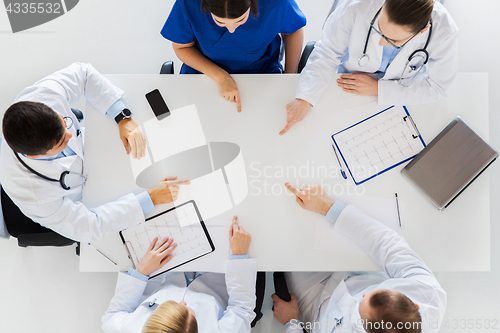 Image of group of doctors with cardiograms working at table