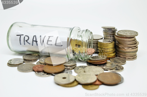 Image of Travel lable in a glass jar with coins spilling out