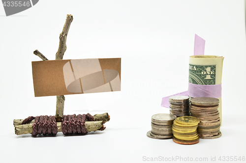 Image of Paper sign board with stack of coins