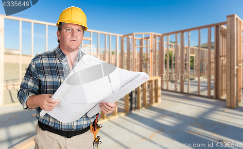 Image of Male Contractor With House Plans Wearing Hard Hat Inside New Hou