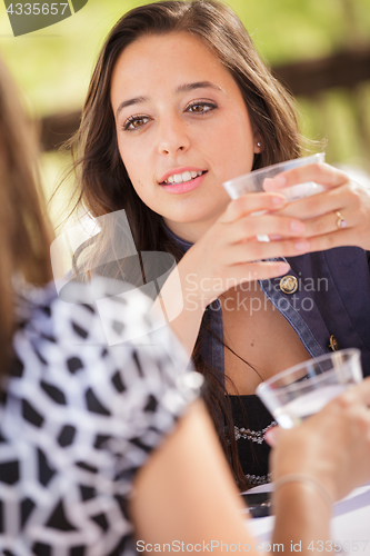 Image of Expressive Young Adult Woman Having Drinks and Talking with Her 