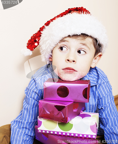 Image of little cute boy with Christmas gifts at home. close up emotional