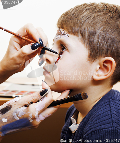 Image of little cute child making facepaint on birthday party, zombie Apo