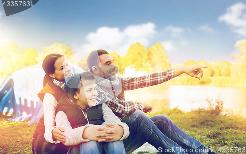 Image of happy family with tent at camp site