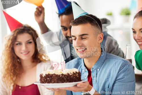 Image of man with birthday cake and team at office party