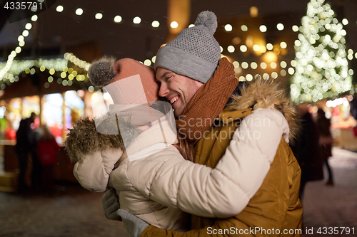 Image of happy couple hugging at christmas tree