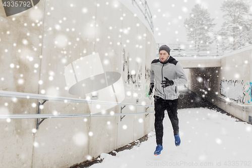 Image of man running out of subway tunnel in winter