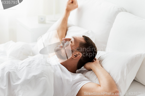 Image of man lying in bed at home