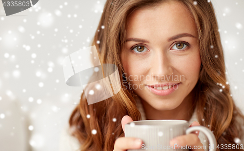 Image of close up of happy woman with coffee cup over snow