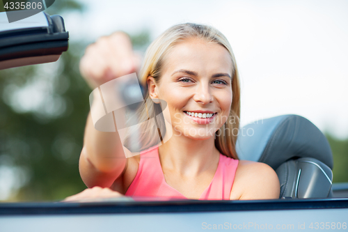 Image of happy young woman with convertible car key