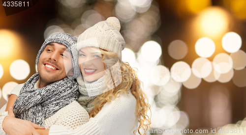 Image of happy couple hugging over christmas lights