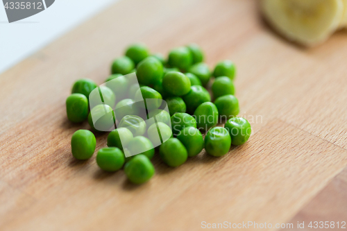 Image of close up of green pea on wooden cutting board