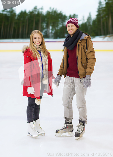 Image of happy couple holding hands on skating rink