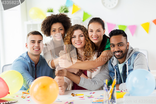 Image of happy team at office party showing thumbs up