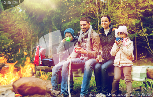 Image of happy family sitting on bench at camp fire