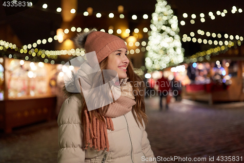 Image of happy young woman at christmas market in winter