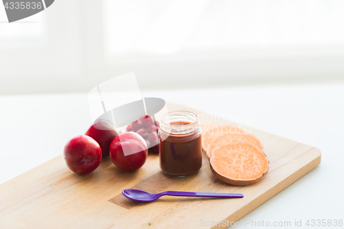 Image of fruit puree or baby food in jar and feeding spoon