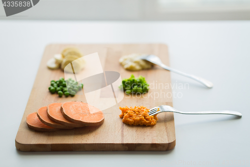 Image of mashed fruits and vegetables with forks on board