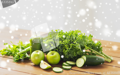 Image of close up of bottle with green juice and vegetables