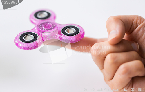 Image of close up of hand playing with fidget spinner