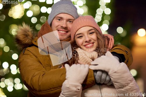 Image of happy couple hugging at christmas tree